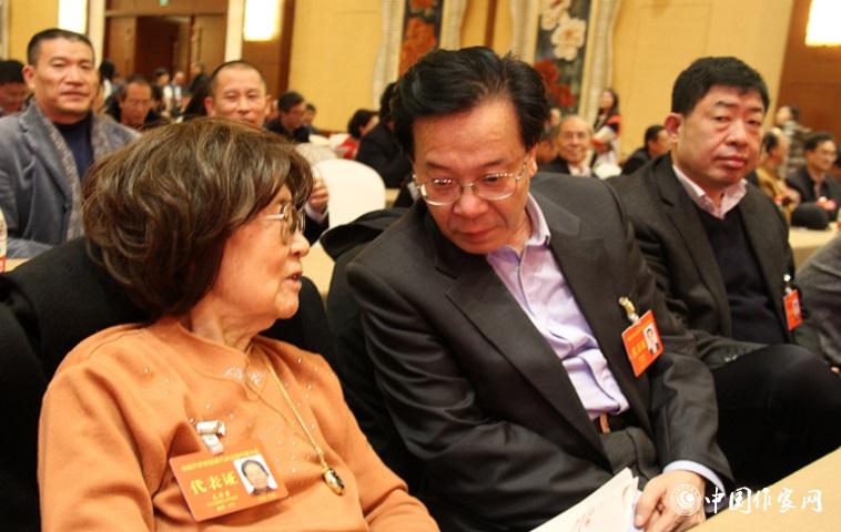 文潔若、李福明等代表在報告會前交談。