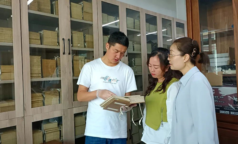 張旻（左）在大通縣圖書館了解、翻閱清代印制的經史子集典籍