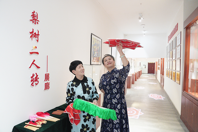 2023年6月29日，在吉林省梨樹縣地方戲曲劇團梨樹二人轉展廊，團長趙丹丹（右一）為作家龔保華講解二人轉技巧。
