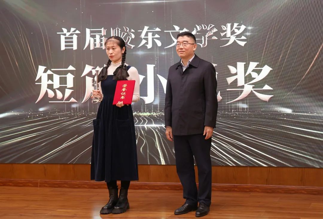 山東省作協(xié)黨組書(shū)記、副主席趙藝?。ㄓ乙唬? 為短篇小說(shuō)獎(jiǎng)獲得者王銘嬋頒獎(jiǎng)