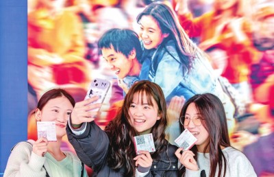 2月18日，觀眾在貴州省黔西市一家影院的電影海報前留影。 新華社發(fā)