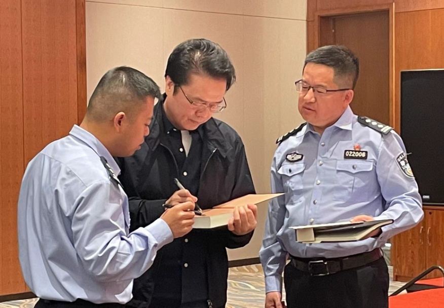 活動期間，陳彥（圖中）在給警營作家簽名。