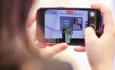 在2024上海國際文學(xué)周主論壇的會場，一位觀眾在用手機錄制日本推理小說家湊佳苗的發(fā)言。上海國際文學(xué)周供圖